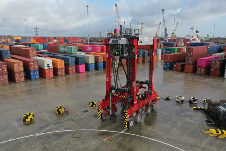 Aerial drone photo showing a large crane vehicle among shipping containers