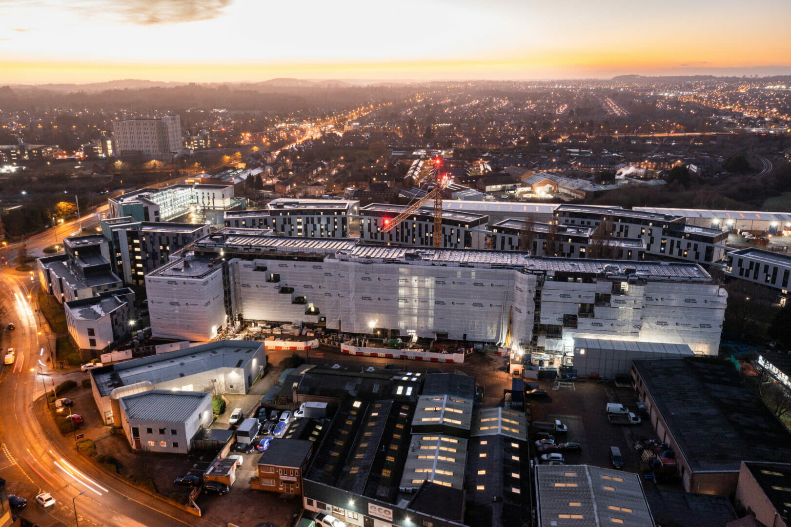 Aerial shot of crane towering above building encased in scaffolding